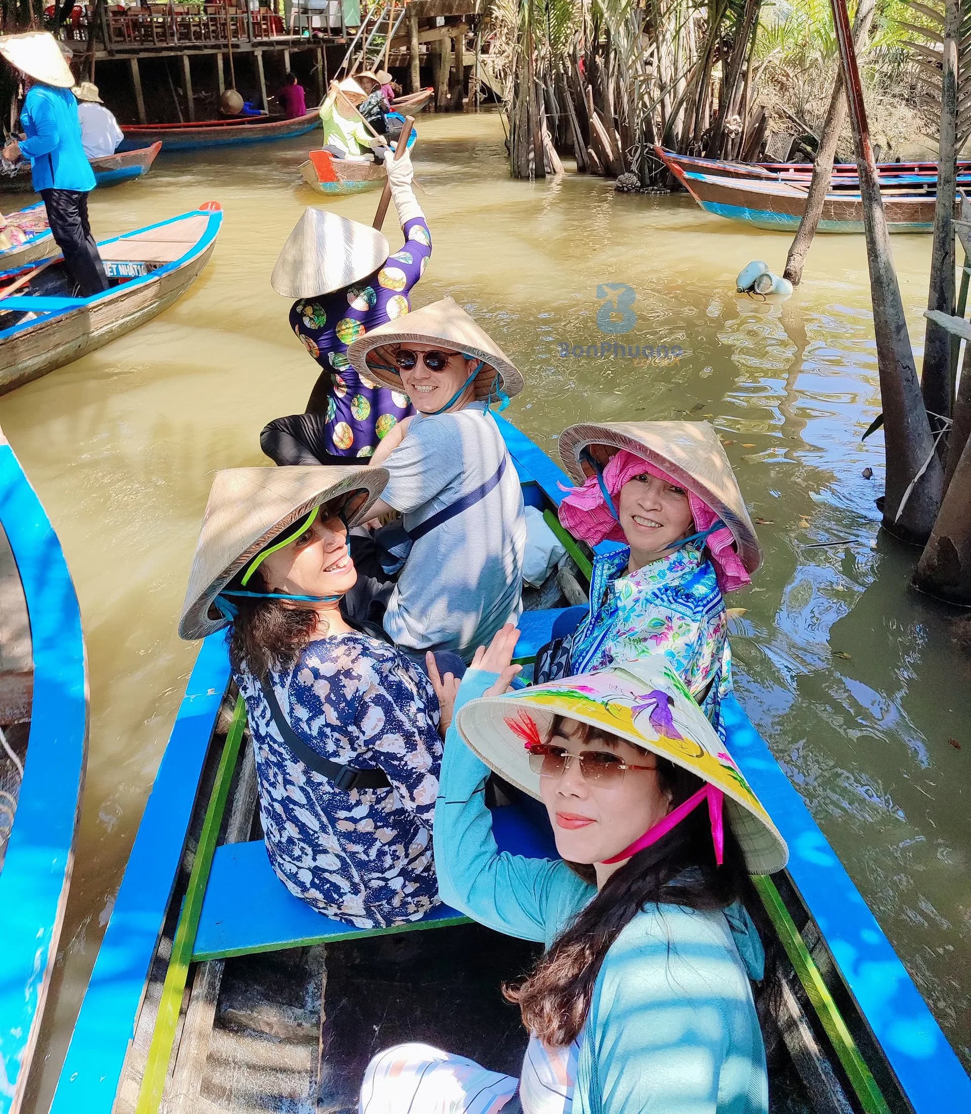 Du khách đội nón lá ngồi xuồng ba lá tham quan Mỹ Tho